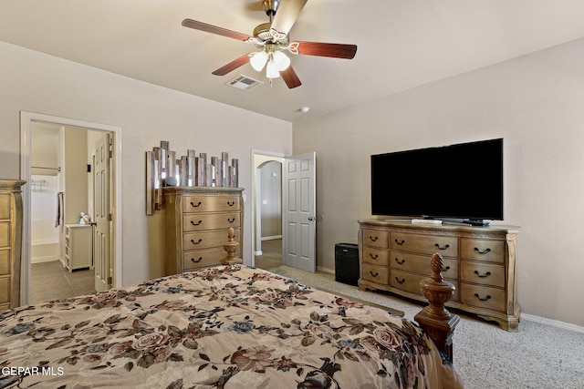 carpeted bedroom with visible vents, a ceiling fan, ensuite bathroom, and baseboards