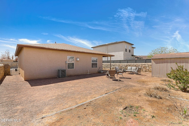 rear view of property featuring central AC unit, stucco siding, a patio, and fence