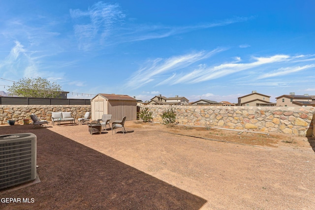 view of yard with an outbuilding, central air condition unit, a shed, and a fenced backyard