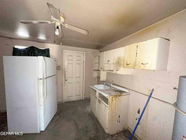 kitchen featuring a sink, a ceiling fan, unfinished concrete floors, and freestanding refrigerator