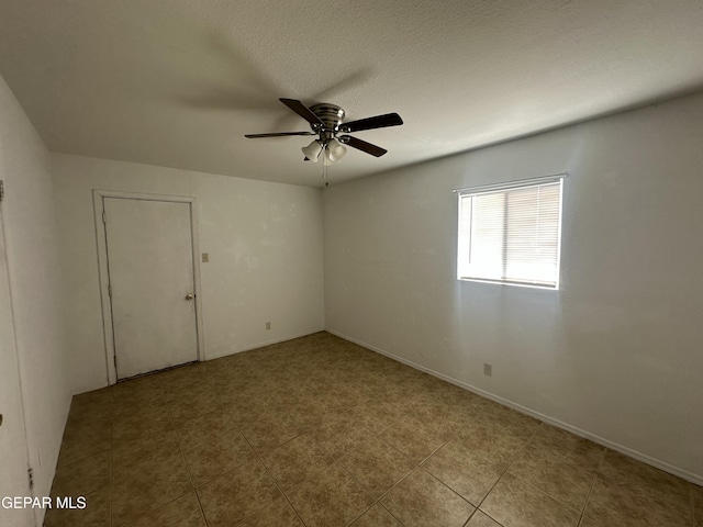 spare room featuring baseboards, a textured ceiling, and a ceiling fan