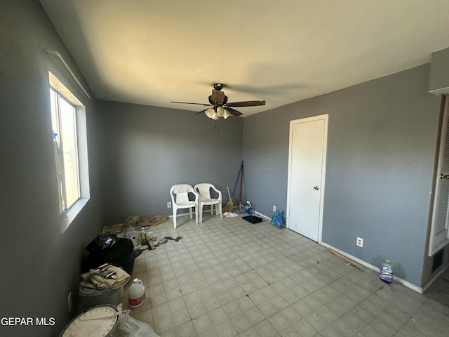 interior space featuring tile patterned floors, baseboards, and ceiling fan