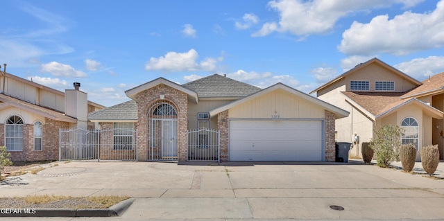 view of front of home with a gate, fence, concrete driveway, an attached garage, and brick siding