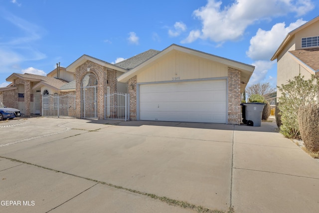 view of front of house with brick siding, driveway, fence, and a gate