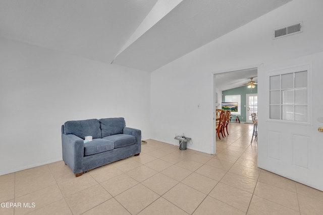 living area featuring light tile patterned flooring, visible vents, ceiling fan, and lofted ceiling