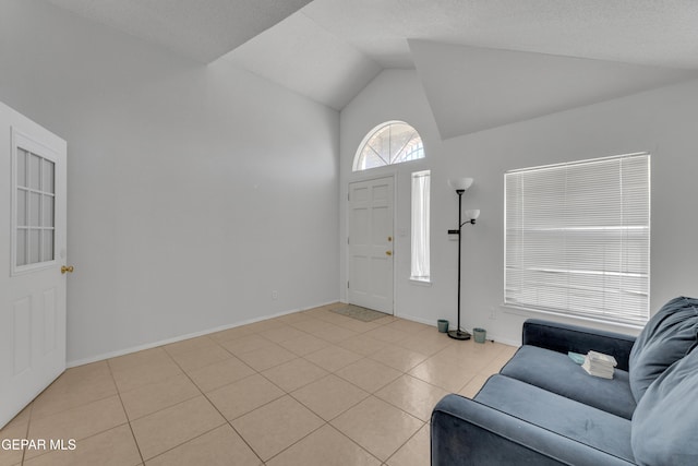 entrance foyer with vaulted ceiling, light tile patterned floors, and baseboards