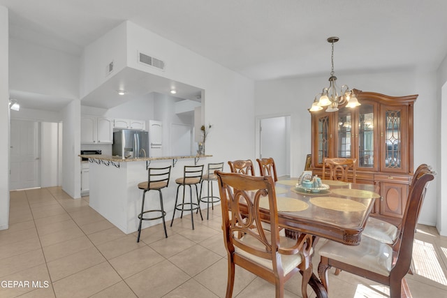 dining area with an inviting chandelier, light tile patterned floors, visible vents, and lofted ceiling