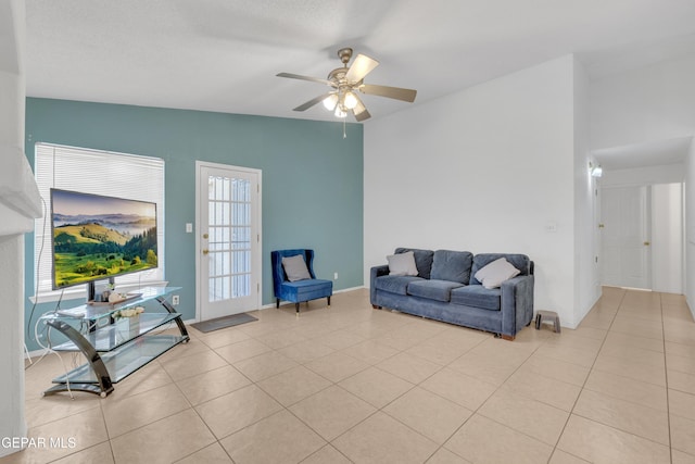 living room featuring light tile patterned floors, a ceiling fan, and vaulted ceiling