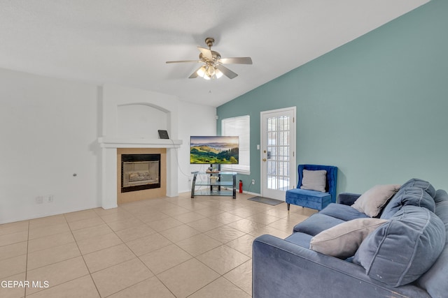 tiled living room with baseboards, lofted ceiling, ceiling fan, and a fireplace