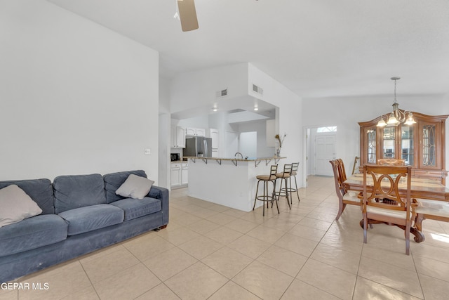 living area featuring visible vents, lofted ceiling, and light tile patterned flooring