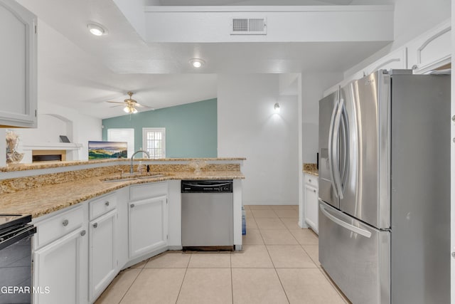 kitchen with visible vents, a sink, stainless steel appliances, vaulted ceiling, and white cabinets