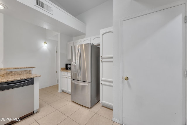 kitchen featuring light tile patterned floors, light stone countertops, visible vents, stainless steel appliances, and white cabinetry