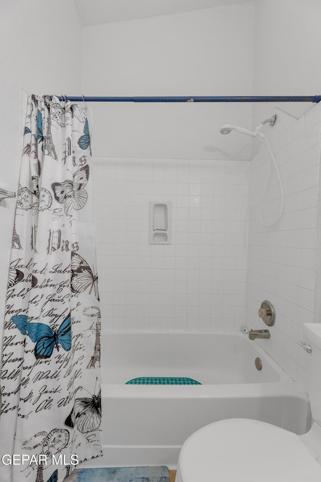 bathroom with shower / tub combo and toilet