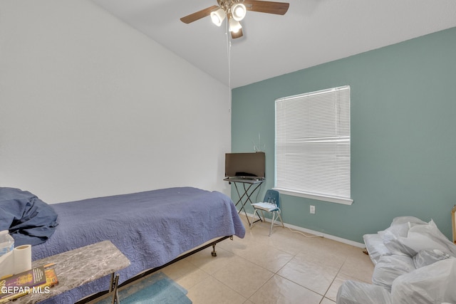 bedroom featuring tile patterned floors, baseboards, a ceiling fan, and lofted ceiling