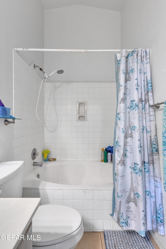 bathroom featuring tiled shower / bath combo, toilet, vanity, and tile patterned floors