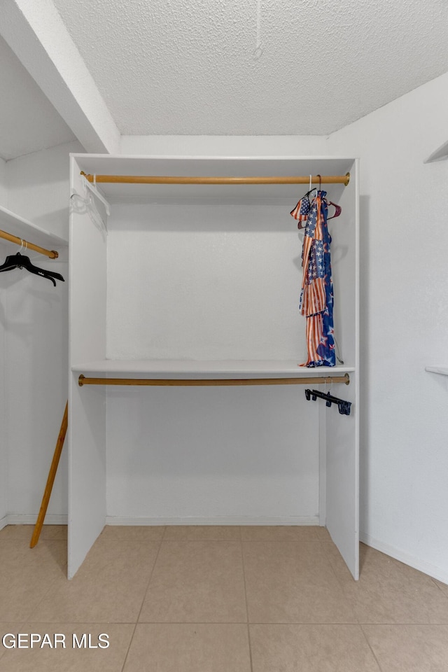 spacious closet with light tile patterned floors