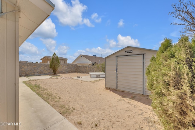 view of yard featuring an outbuilding, a shed, and a fenced backyard