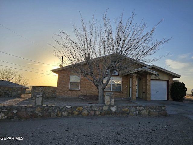 view of front of property with a garage, brick siding, and concrete driveway