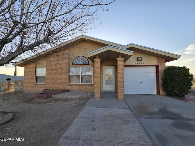 view of front facade featuring brick siding, driveway, and a garage