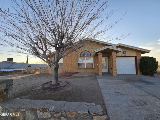 ranch-style home featuring brick siding, an attached garage, and concrete driveway