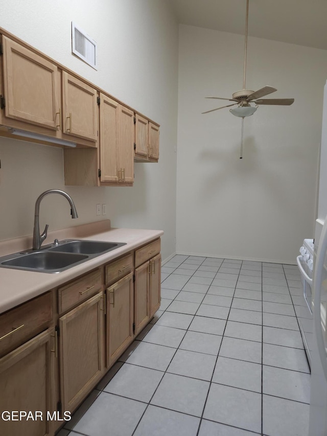 kitchen with visible vents, light tile patterned flooring, ceiling fan, a sink, and light countertops