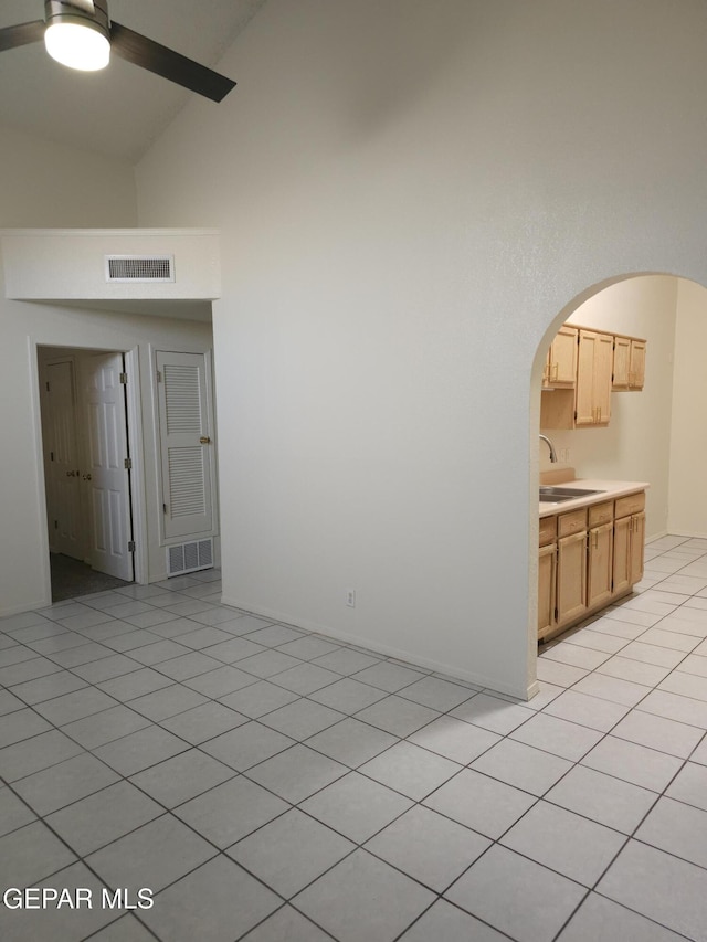 spare room with arched walkways, visible vents, high vaulted ceiling, and a sink