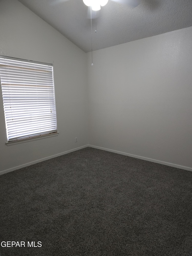 carpeted empty room with baseboards and lofted ceiling