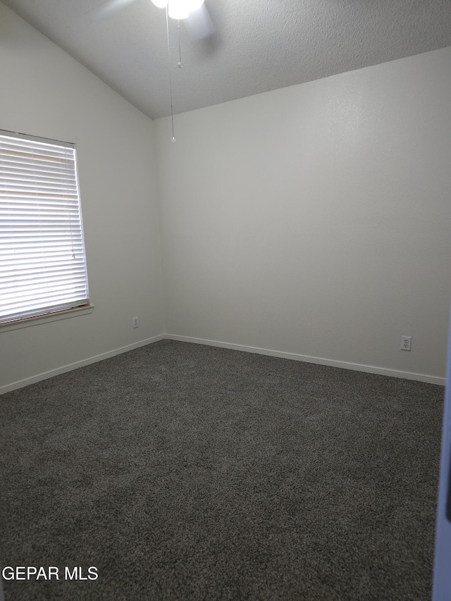 carpeted empty room with baseboards, lofted ceiling, a textured ceiling, and ceiling fan