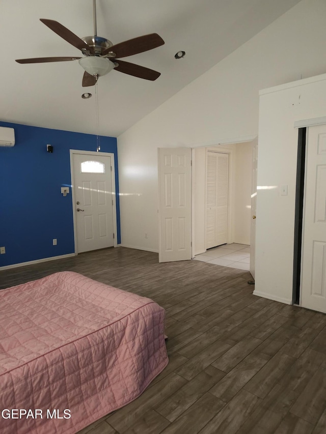 bedroom featuring baseboards, an AC wall unit, wood finished floors, and a ceiling fan