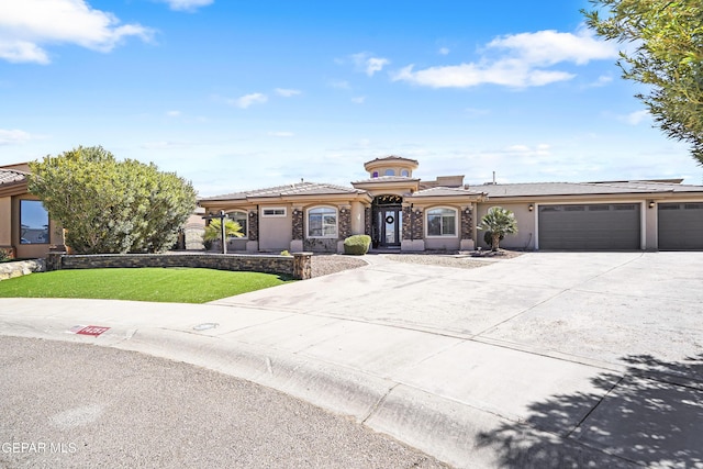 view of front facade with a front lawn, a tiled roof, concrete driveway, stucco siding, and a garage