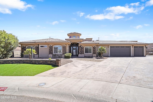 view of front facade with a front yard, driveway, an attached garage, stucco siding, and a tiled roof