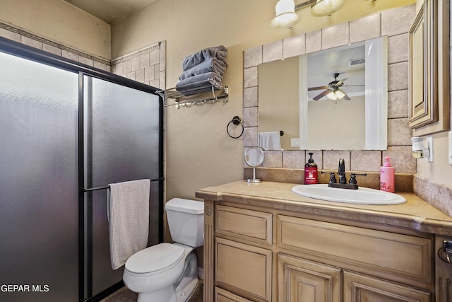 full bath with toilet, a stall shower, a ceiling fan, tasteful backsplash, and vanity