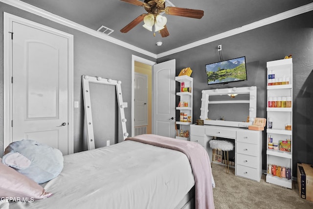 carpeted bedroom featuring visible vents, crown molding, and ceiling fan