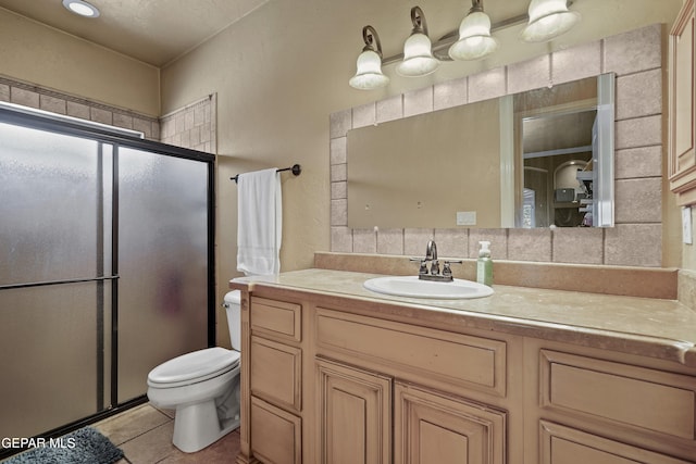 bathroom featuring tasteful backsplash, toilet, a stall shower, tile patterned floors, and vanity