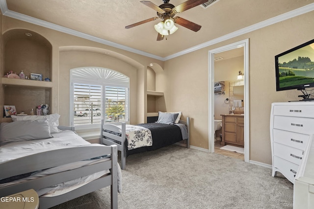 bedroom with visible vents, baseboards, light colored carpet, ornamental molding, and ensuite bath