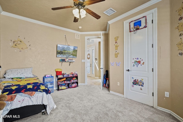 carpeted bedroom featuring visible vents, baseboards, crown molding, and a ceiling fan