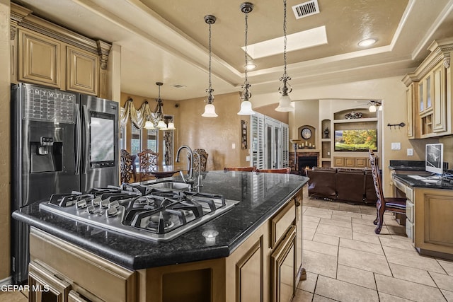 kitchen featuring visible vents, built in shelves, a sink, stainless steel appliances, and a raised ceiling