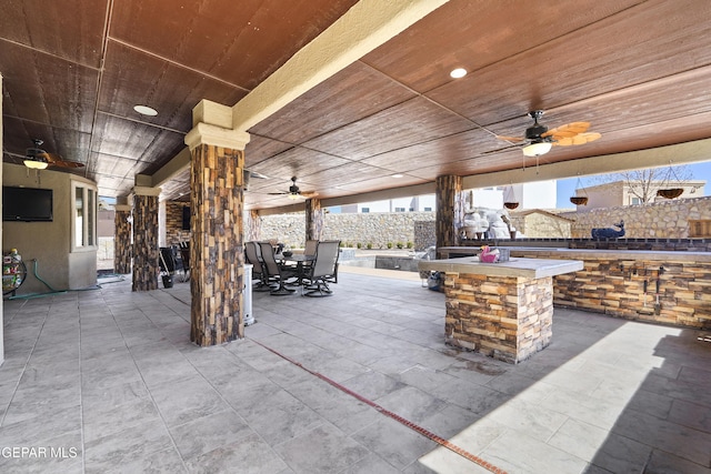 view of patio featuring outdoor dining area, ceiling fan, outdoor dry bar, and fence