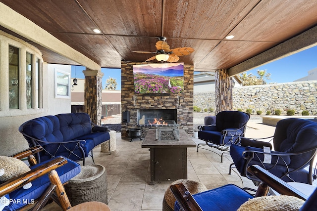 view of patio / terrace with ceiling fan, a fenced backyard, and an outdoor living space with a fireplace