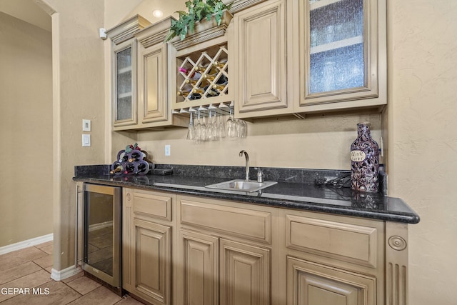 bar featuring light tile patterned floors, beverage cooler, baseboards, a sink, and indoor wet bar