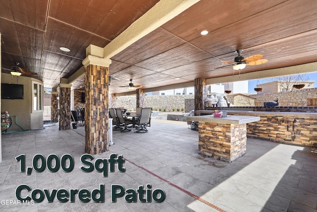 view of patio / terrace featuring outdoor dining space, fence, outdoor dry bar, and ceiling fan