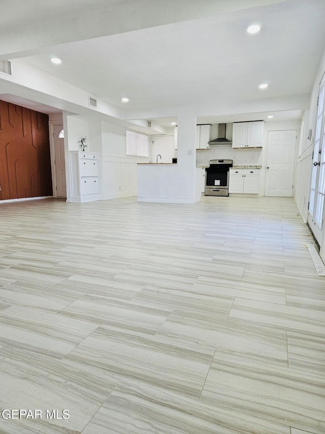 unfurnished living room with recessed lighting and visible vents