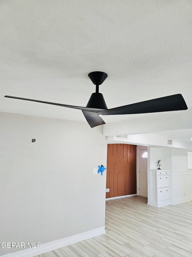 spare room featuring visible vents, a textured ceiling, and light wood-style flooring