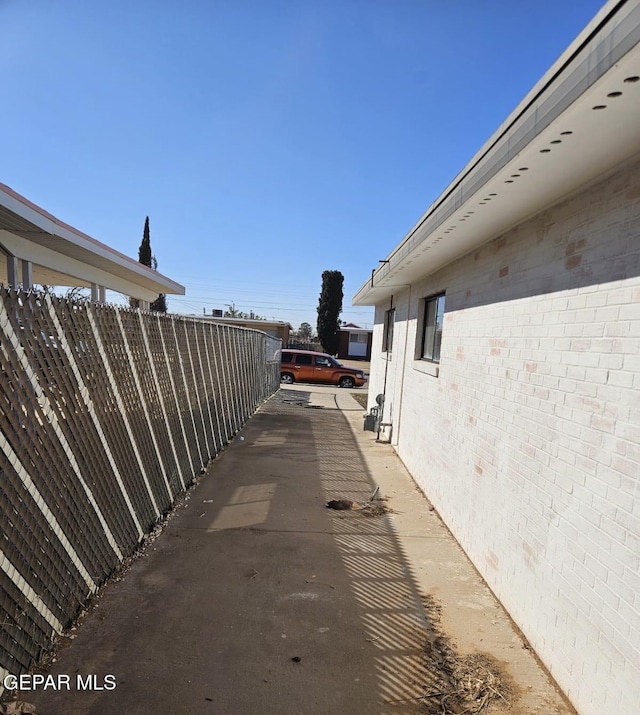 view of side of home with fence and brick siding