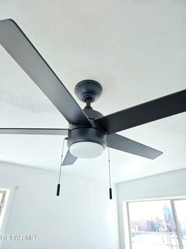 interior details with a textured ceiling and ceiling fan