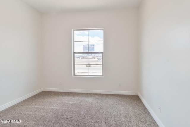 carpeted empty room with baseboards