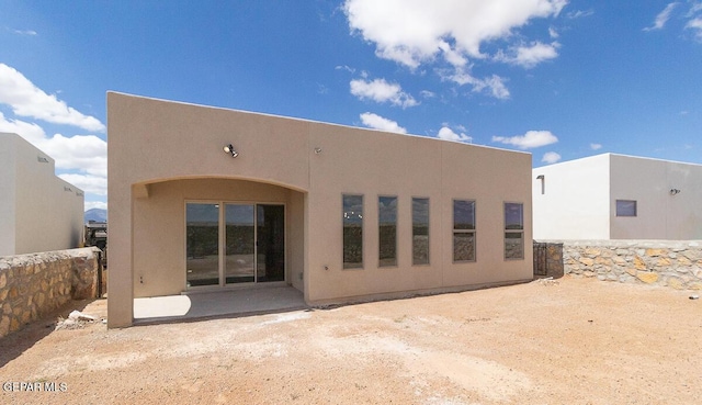 rear view of property featuring stucco siding and a patio