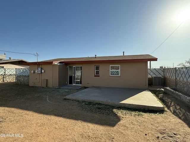 back of house with central air condition unit, fence private yard, stucco siding, and a patio area