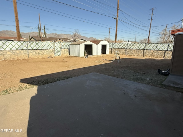 view of yard with an outbuilding, a patio, a storage shed, and a fenced backyard