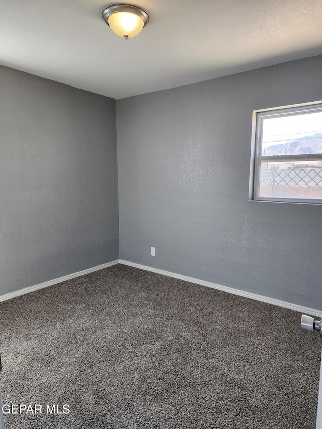 unfurnished room featuring carpet flooring and baseboards